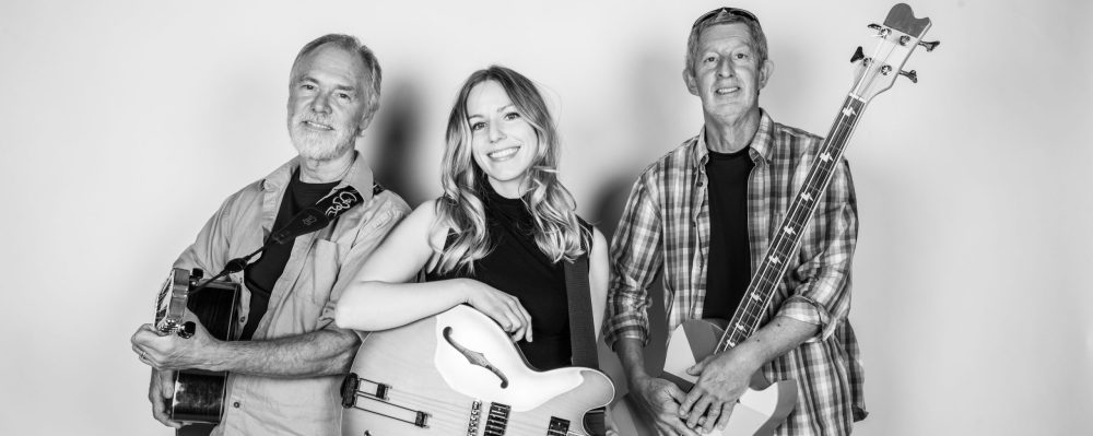 Three people hold instruments.